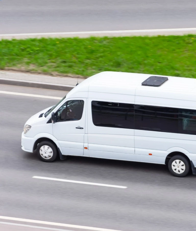 bus jadący ulicą, trawa